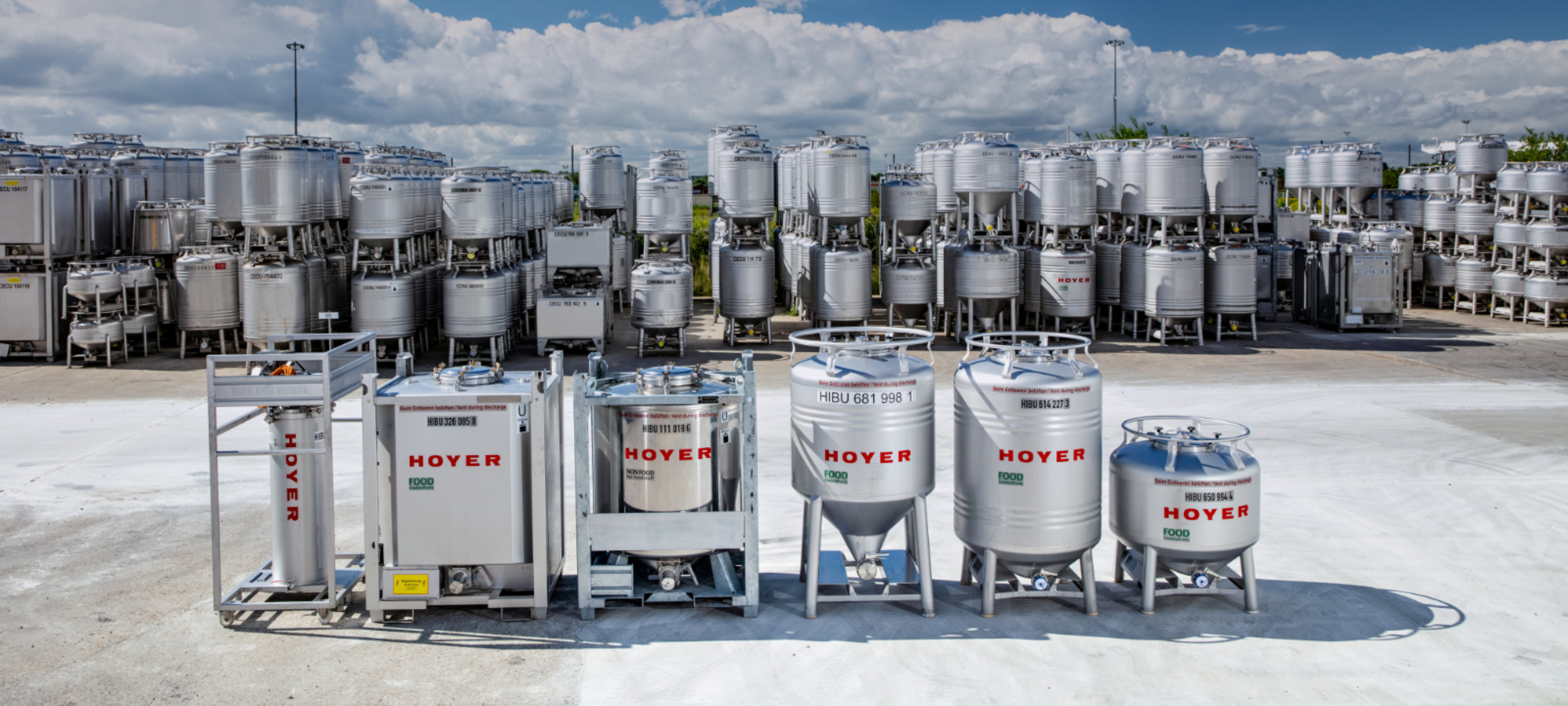 IBC-food-and-non-food-HOYER-Group-in-background-in-depot Food and non-food IBCs of the HOYER Group stand stacked up in the depot.