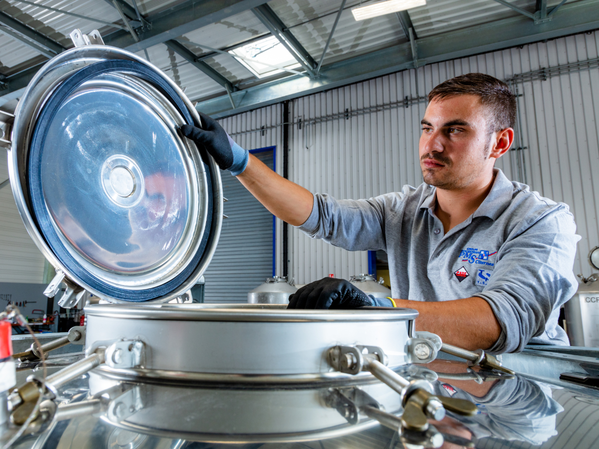 Un collaboratore apre il coperchio di un IBC 